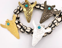 Cargar imagen en el visor de la galería, Colgante de cabeza de dirección de peltre de 2,25x2,75 pulgadas con howlita turquesa en oro, latón, oro mate, plata mate